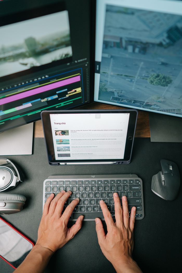 portfolio-01 Person typing on keyboard in modern workspace with multiple screens displaying content.