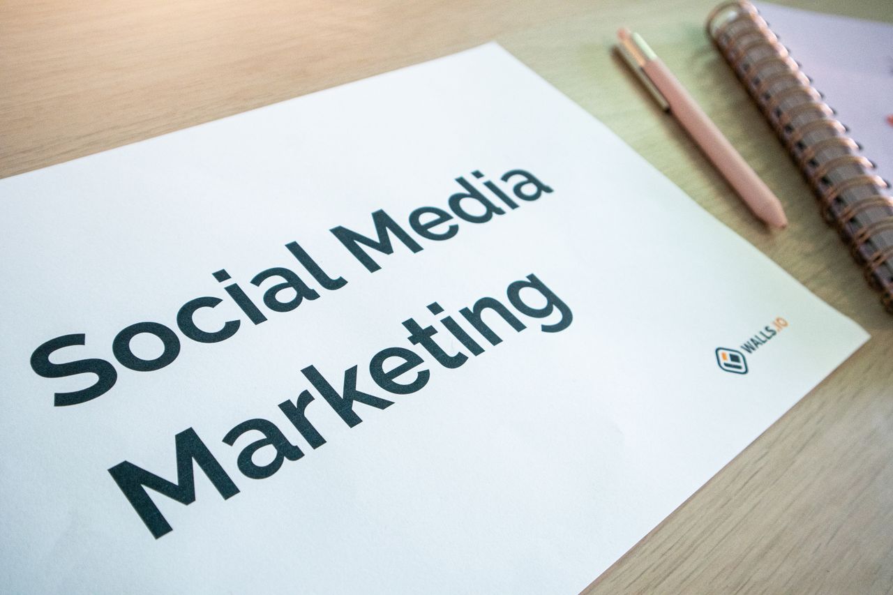 portfolio-05 Close-up of a social media marketing document on a desk with a pen and notebook.